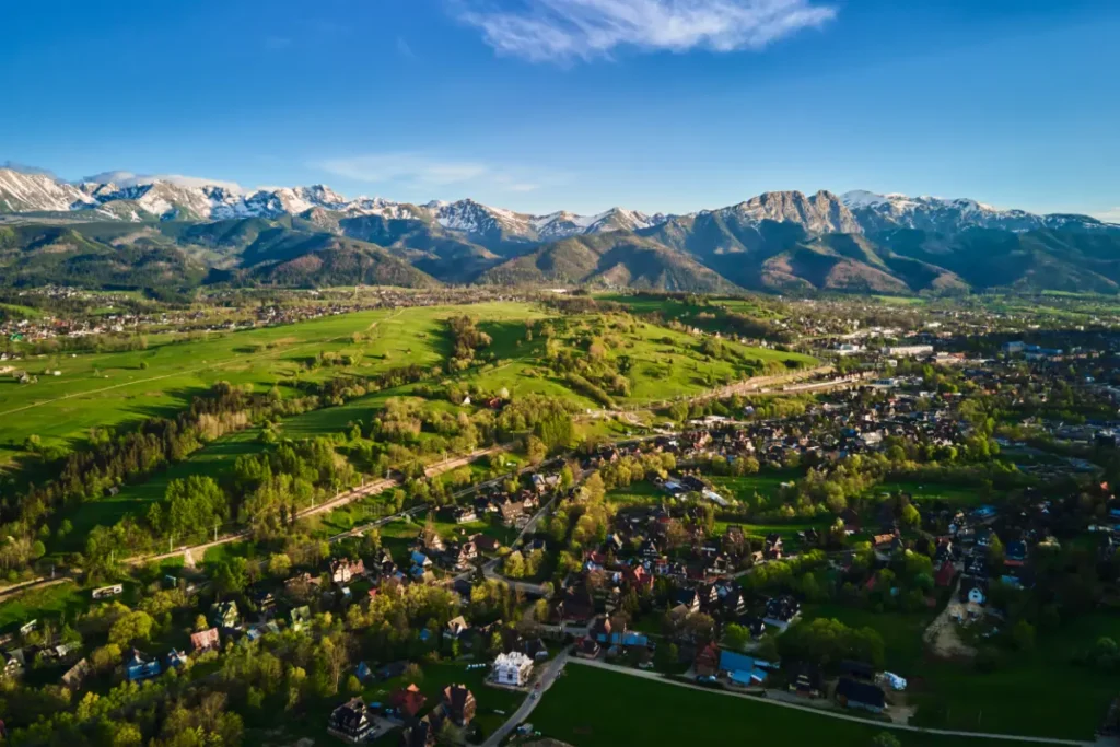 Widok z lotu ptaka na Zakopane, widać miasto Harendę, i panoramę Tatr, Artykuł Zakopane czy Kościelisko